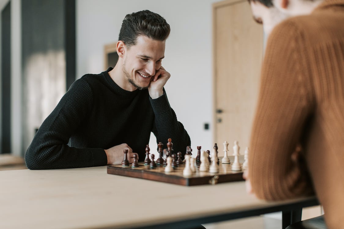 A laughing man during chess game.