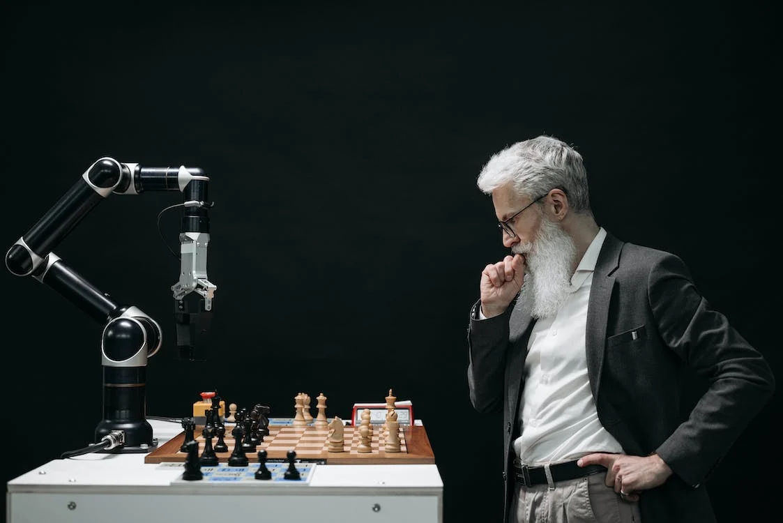 Man playing chess against robot